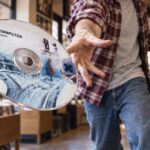 Egy férfi Radiohead OK Computer feliratú CD-t dob a kamera felé egy lemezboltban.