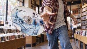 Egy férfi Radiohead OK Computer feliratú CD-t dob a kamera felé egy lemezboltban.