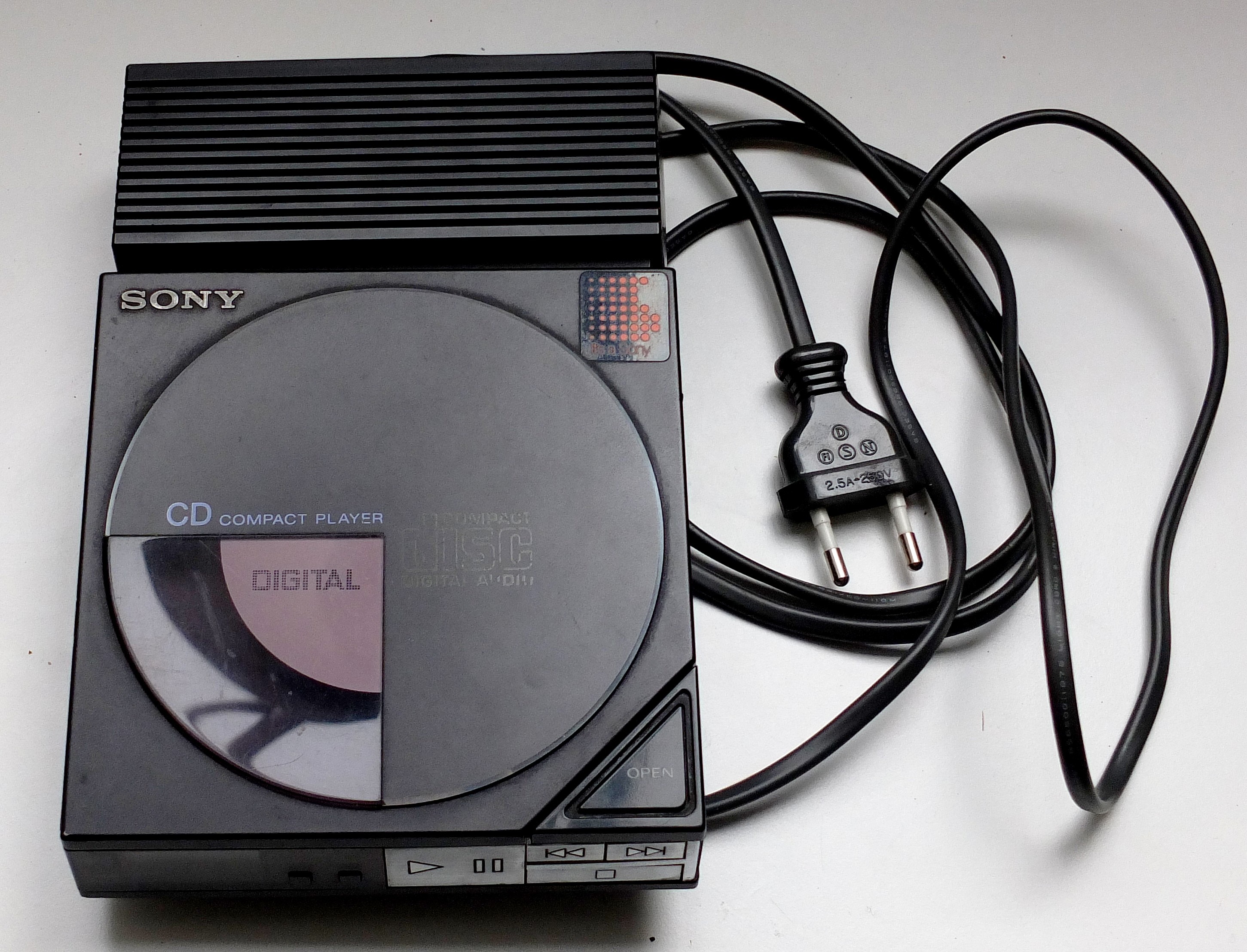 Sony D-50 hordozható CD-lejátszó a hálózati adapteréhez csatlakoztatva.